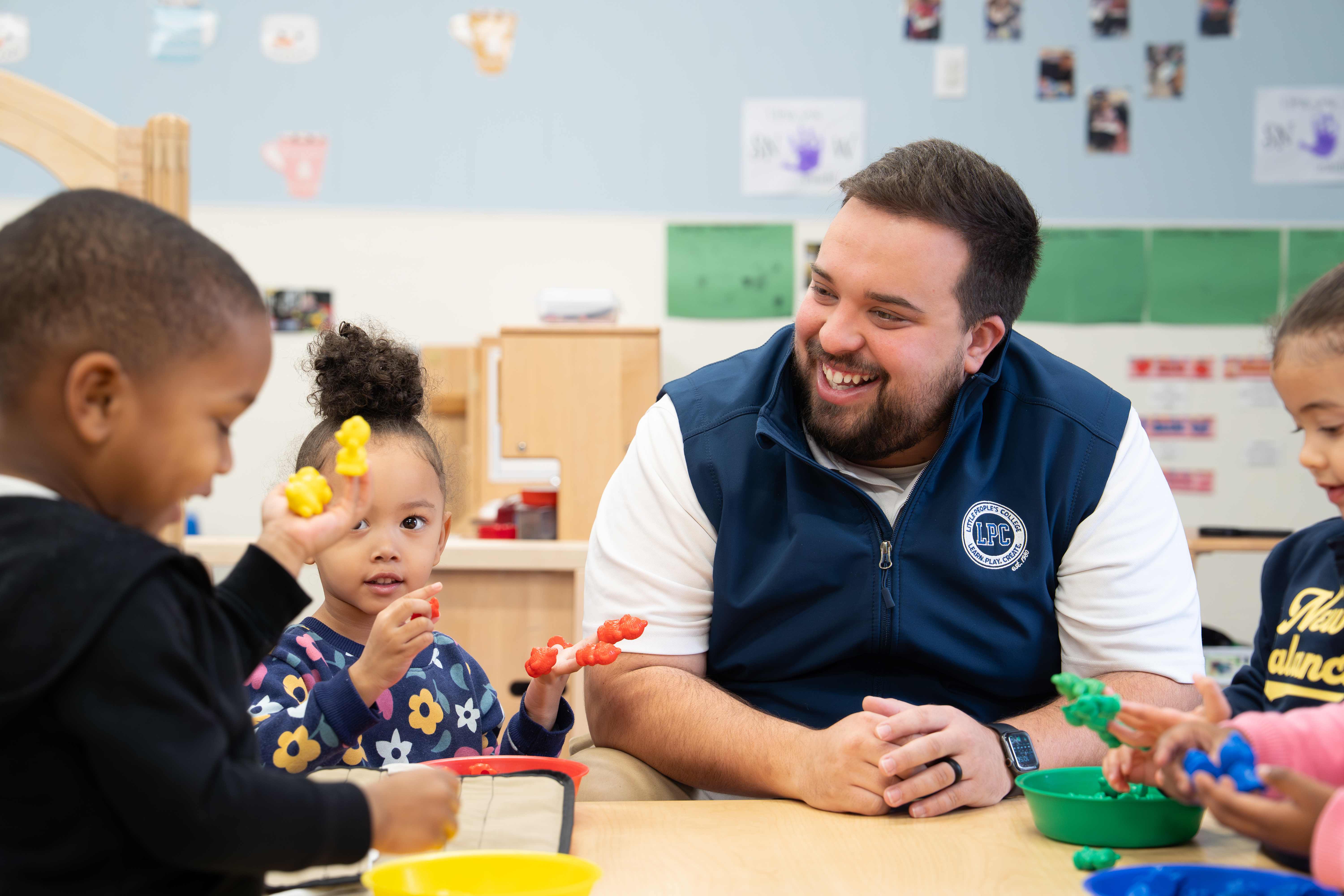 LPC teacher interacting with children during a play-dough activity in classroom
