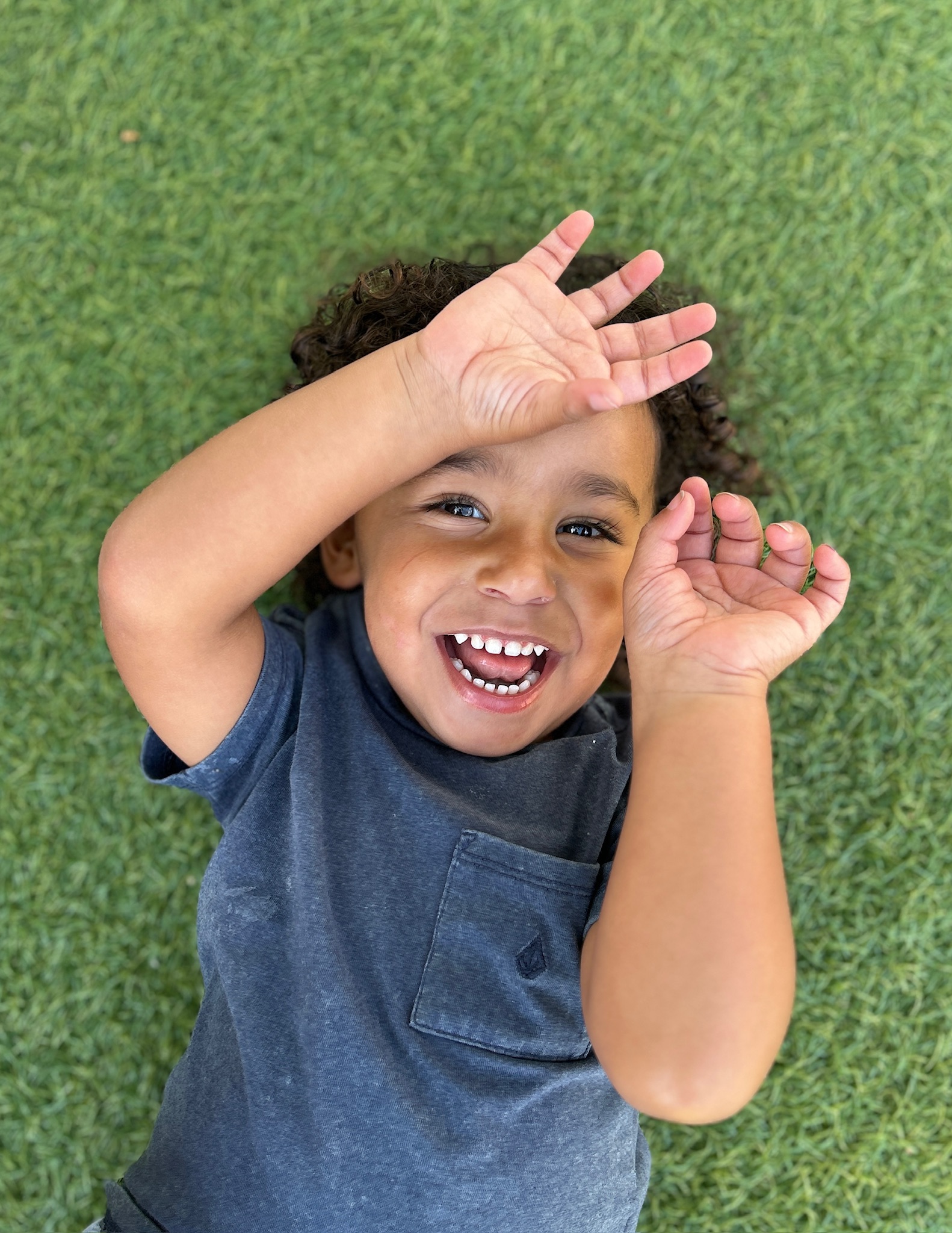 Laughing child lying on green grass