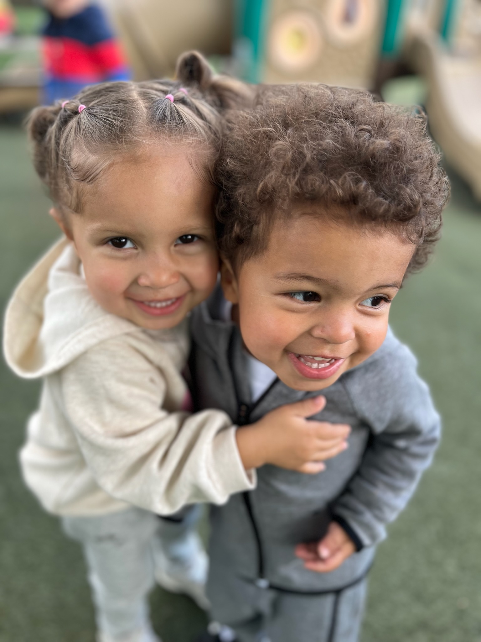 Two young children hugging on the playground